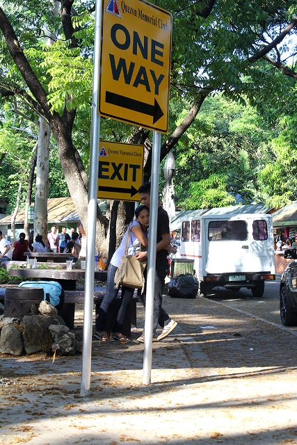 A tender moment softens the utilitarian characteristics of park signage. (Quezon Memorial Park, Quezon City)