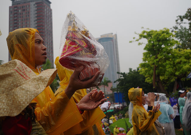 One of the hundreds of devotees holding a relic of Sto. Niño as Pope Francis celebrates concluding Mass at the Quirino Grandstand. (Photo by Fred Dabu / Bulatlat.com)