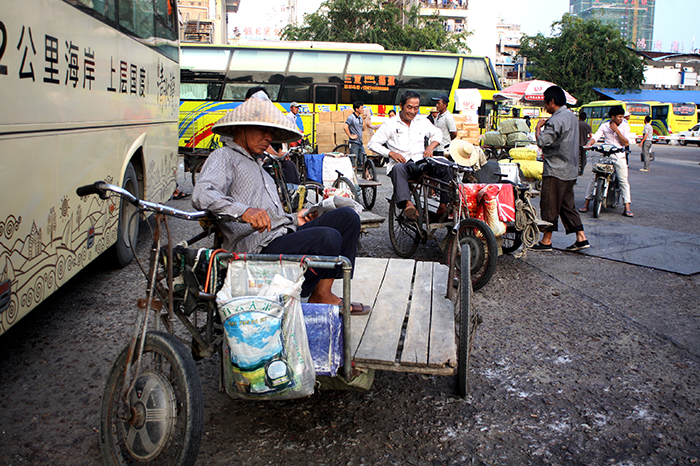  As a tourist town booms around them, these tricycle drivers seem to find it hard to compete with the slick tourist buses that bring in droves of visitors to their once sleepy town. (Sanya City, Hainan Island Province, People's Republic of China)