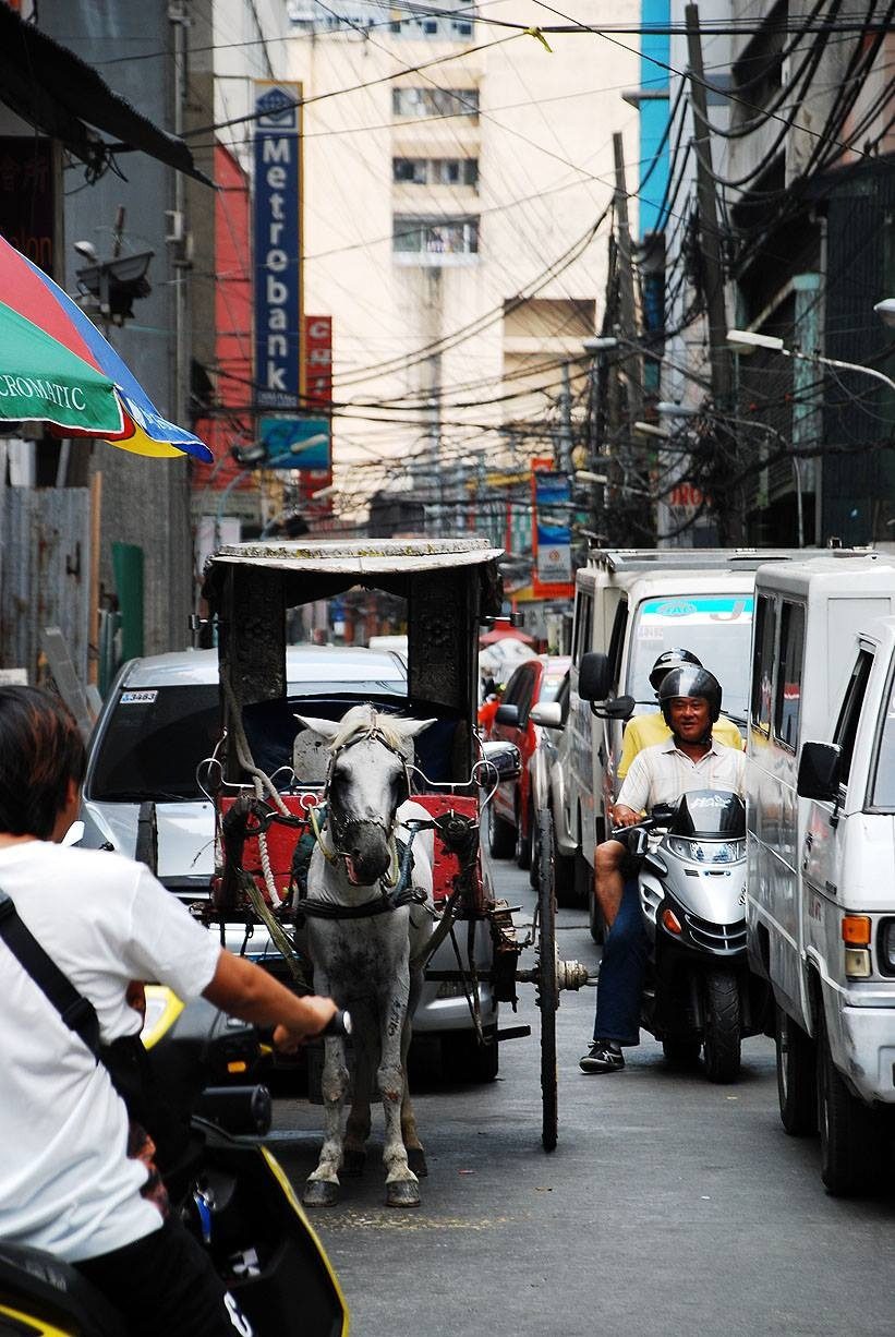 A 'karwaje' gets tangled in traffic among modern modes of transportation in Chinatown, Binondo. (Photo by Cong Corrales / Bulatlat.com) 