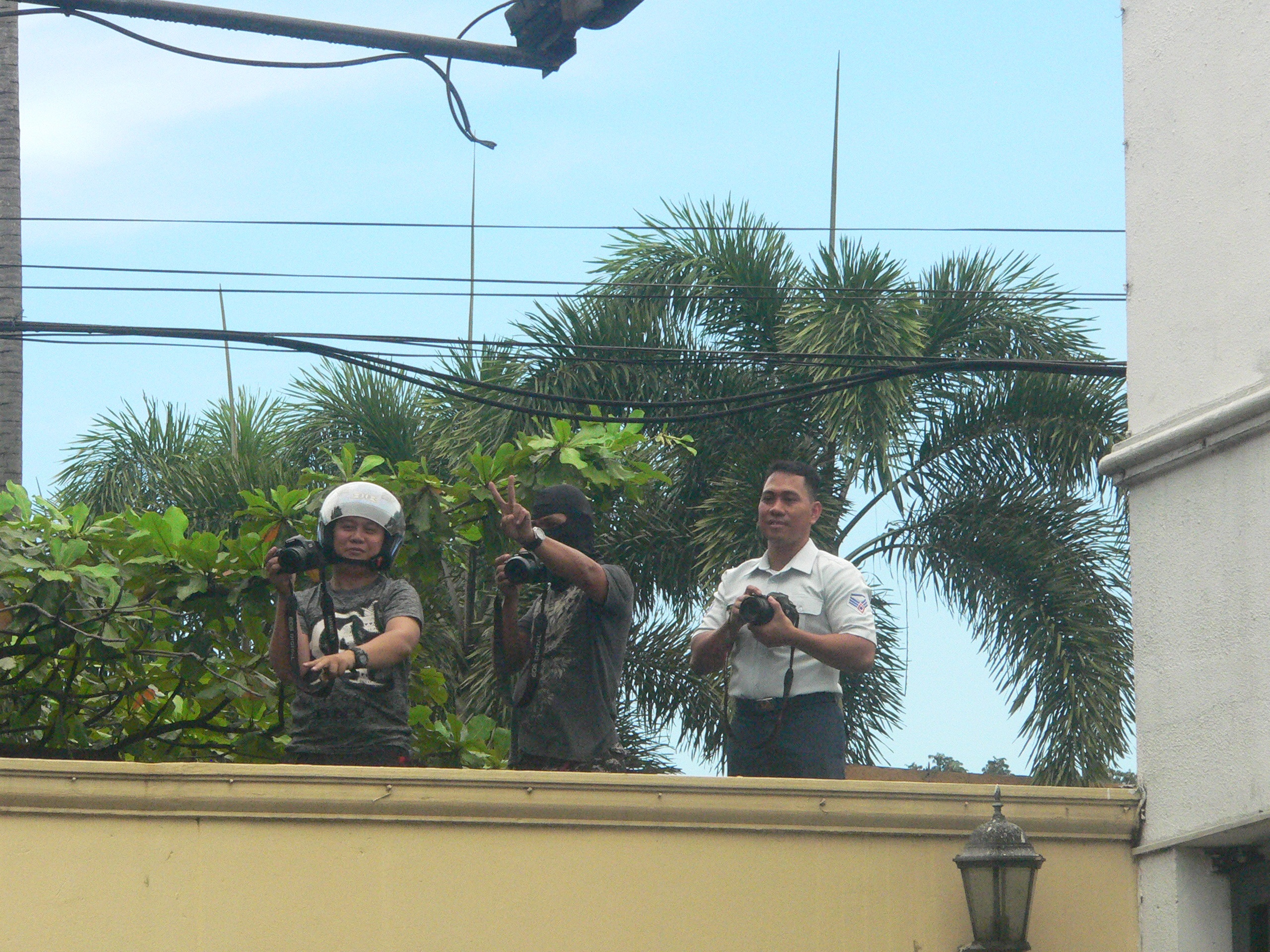 PEACE? AFP personell, including one in a ski mask, take photos of protesters over the Camp Aguinaldo wall (Photo by D.Ayroso/Bulatlat.com)